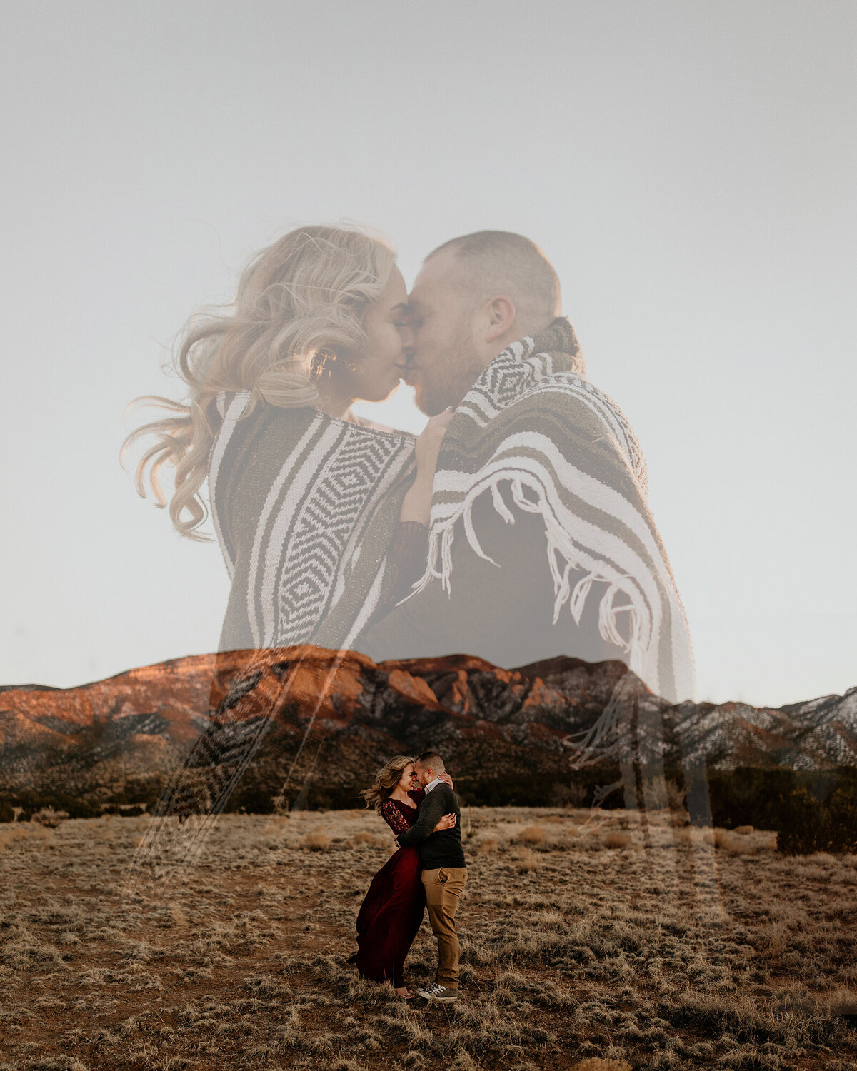 engaged couple wrapped up in a blanket together in the desert
