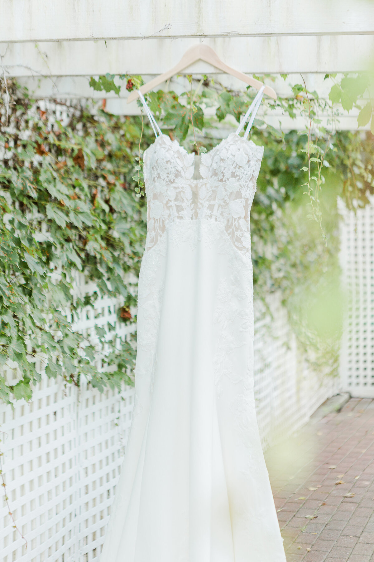 Close up image of bride's down hanging from a pergola. Captured by best Massachusetts wedding photographer Lia Rose Weddings.