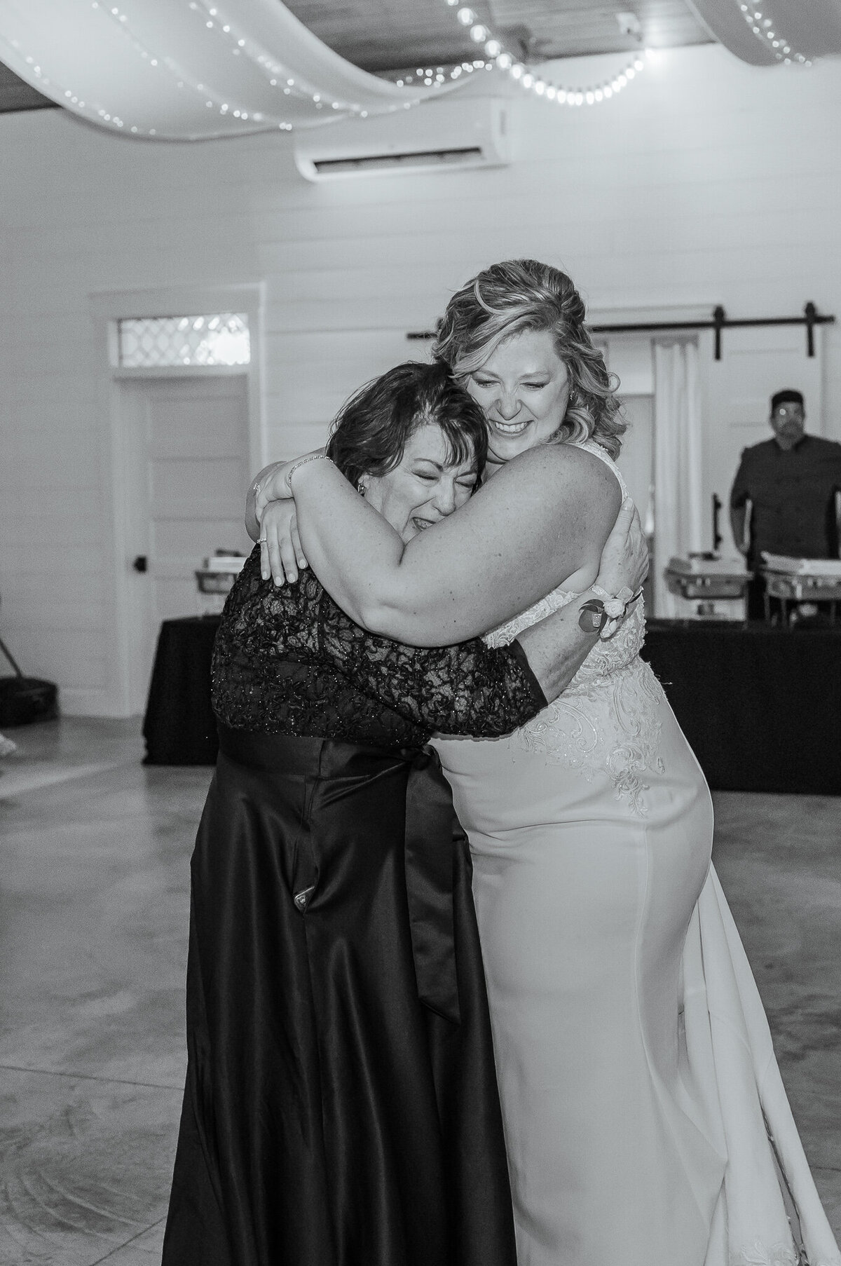 A crying mother hugging her daughter during their mother daughter dance on her wedding day while enjoying their Raleigh wedding photography session by JoLynn Photography