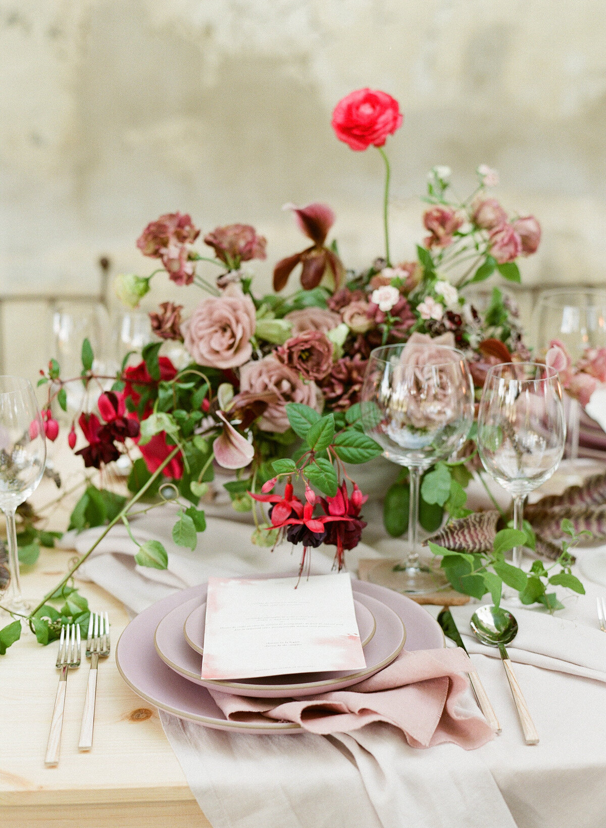 Stunning floral decoration at a tabletop with wine glasses and cutlery items.