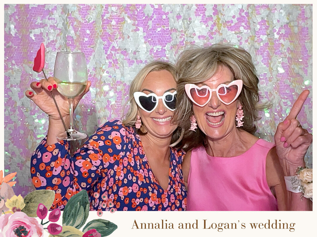 two wedding guests in pink using a photo booth at a wedding in christchurch with a pink sequin backdrop