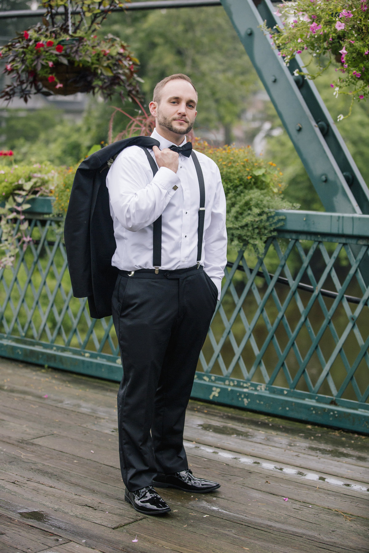 groom on bridge with flowers at riverview wedding