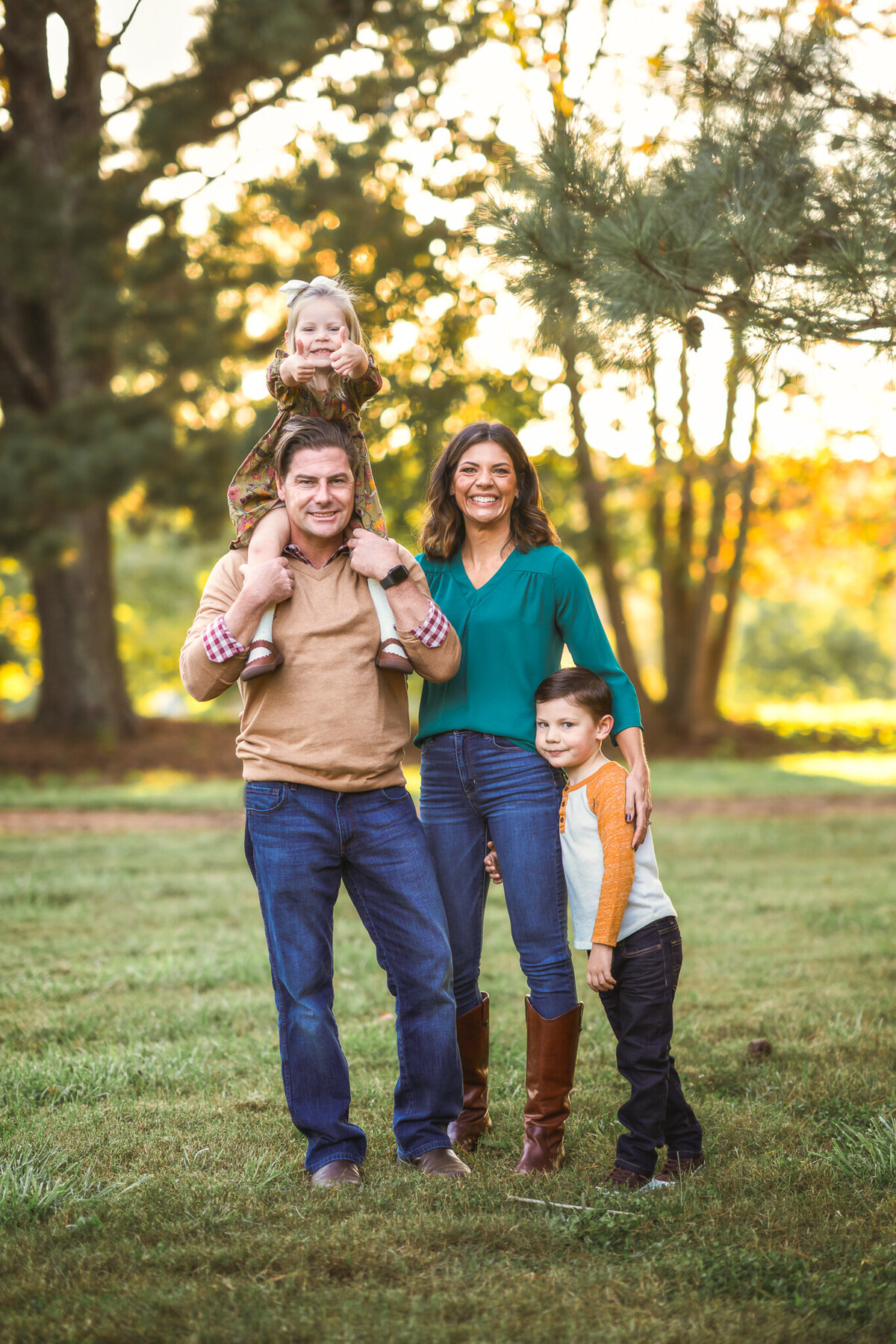 A family of four is standing in a park and posing for their family pictures in Newnan, GA.