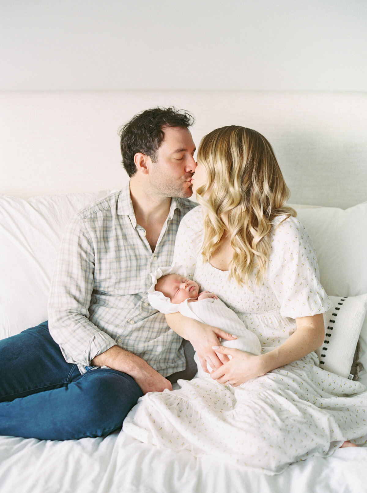 parents in master bedroom holding new baby girl by photographer in madison wi talia laird photography