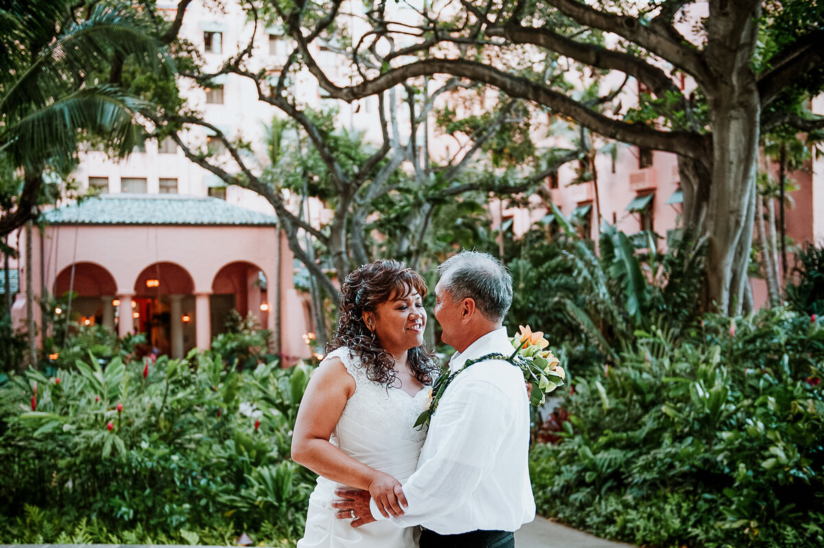 A Bride and Groom Pose for a Photo Outside of the Royal Hawaiian Hotel
