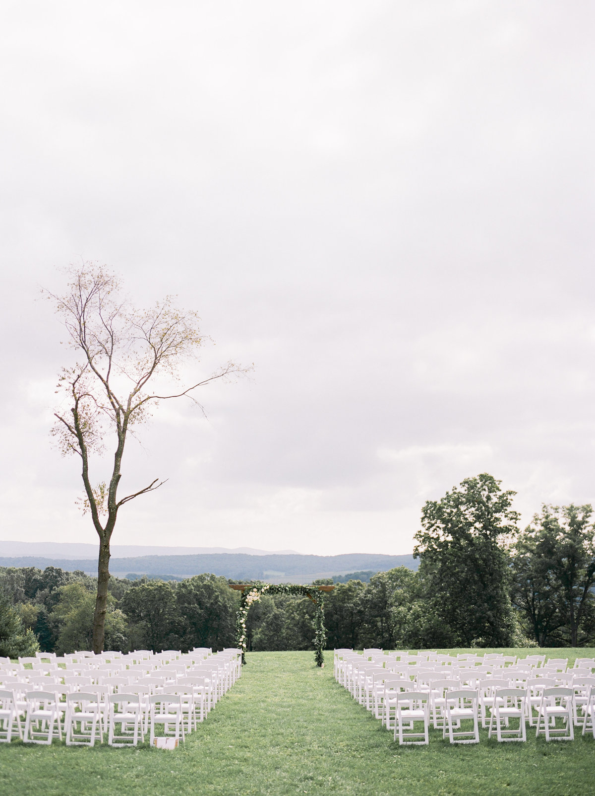 lawn overlooking mountains with chairs at outdoor wedding ceremony