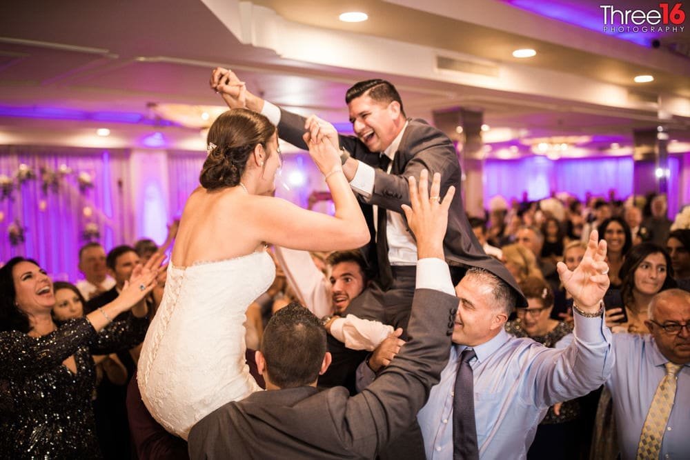 Bride and Groom get carried away on the shoulders of their guests