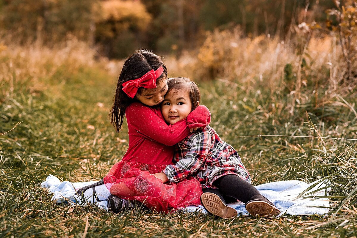 Sisters hugging in a field