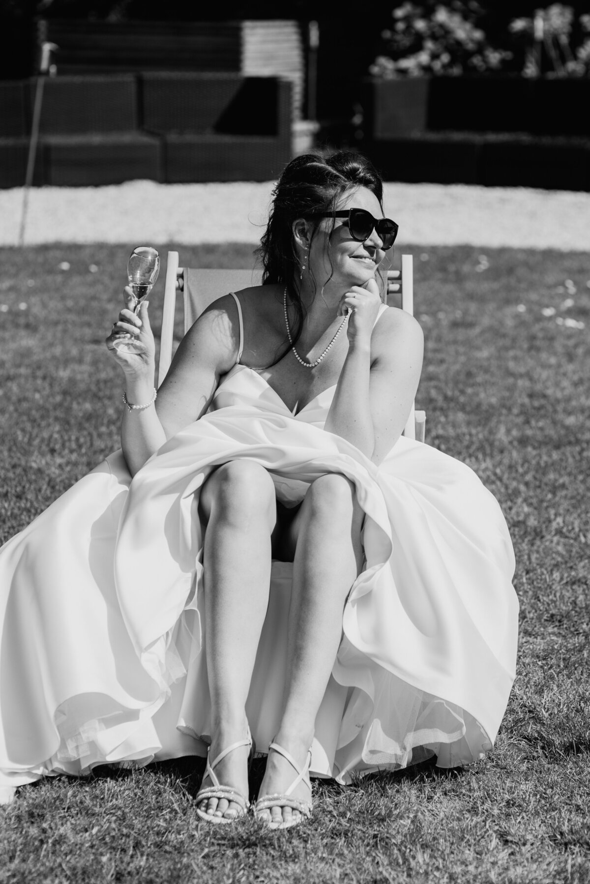 Bride sitting with sunglasses and champagne glass