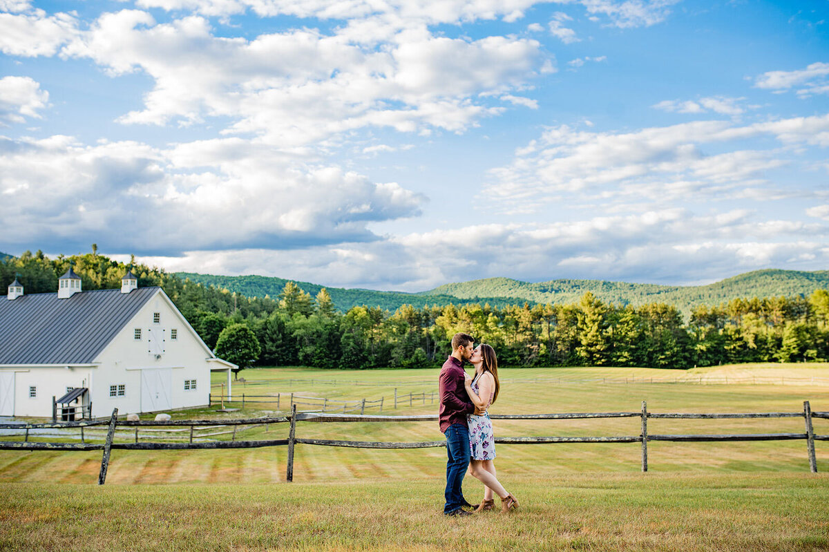couple kissing in field at riverside farm in pittsfield vermont wedding