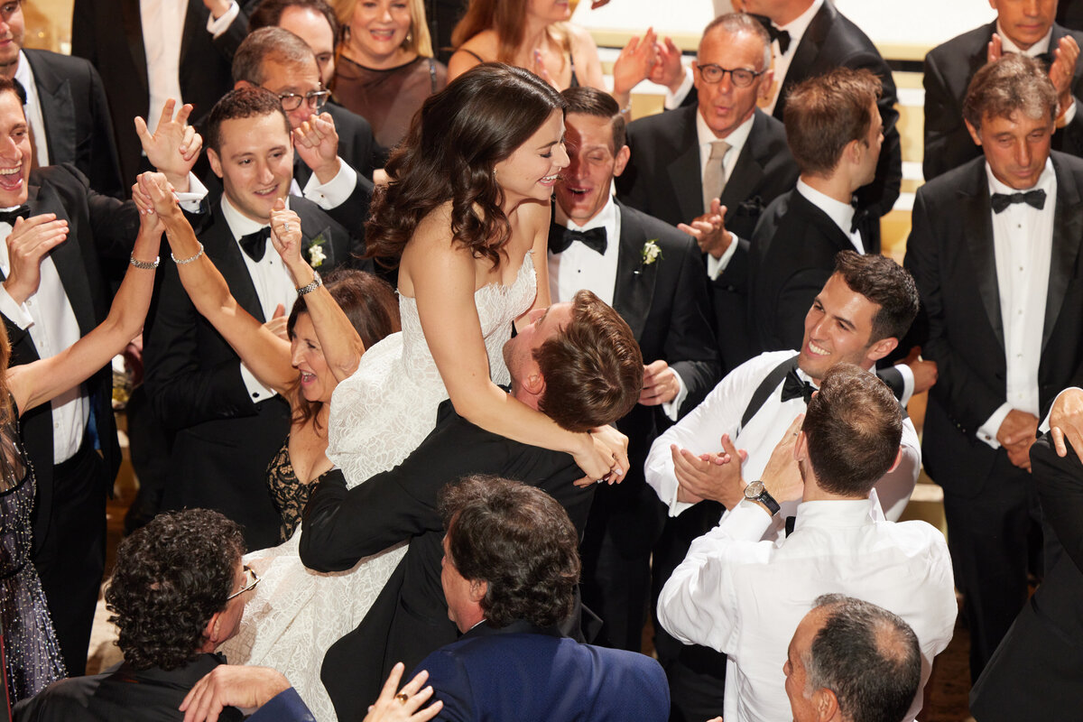 bride and groom dancing at reception with crowd