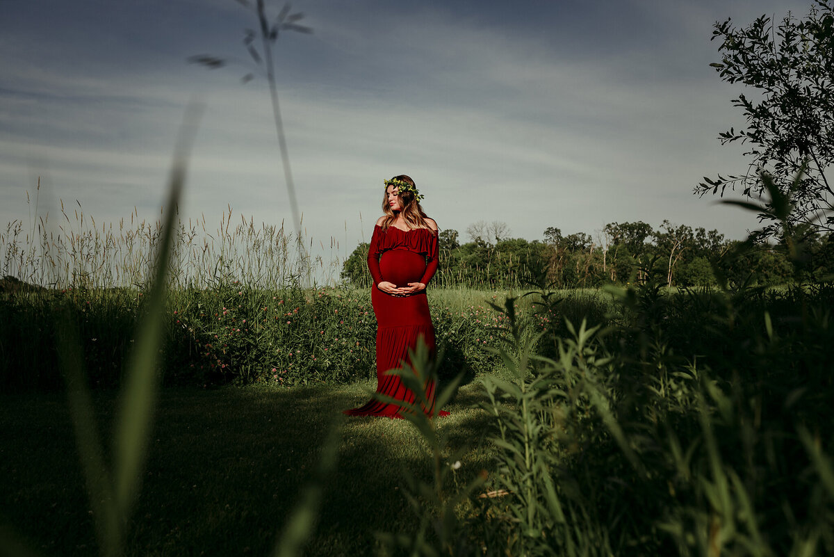maternity portrait of a woman in a red dress outside and beautiful lighting,