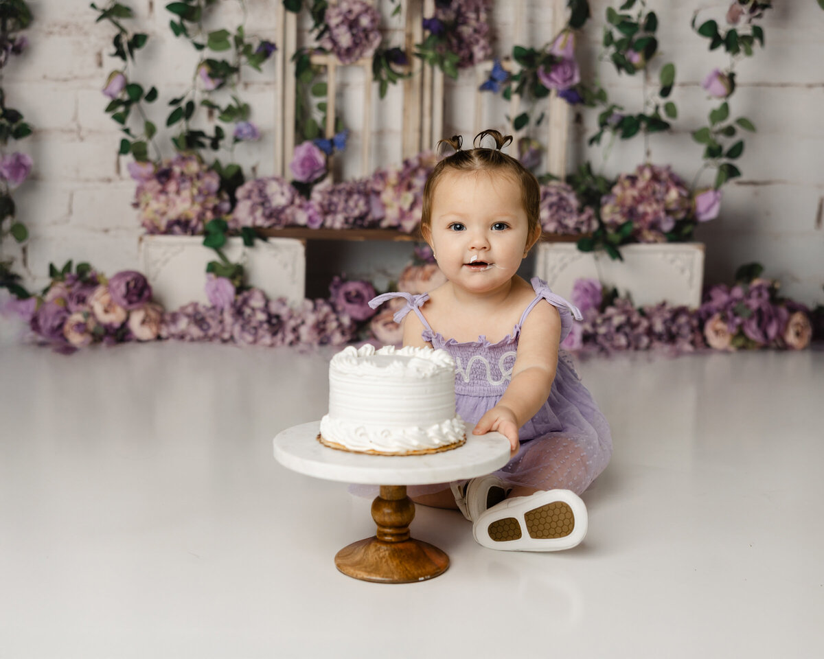 Every giggle, every frosting-covered smile captured forever. This purple floral cake smash session is a celebration of pure happiness, photographed by Yucaipa cake smash photographer Kaitlyn Dawn Photography.