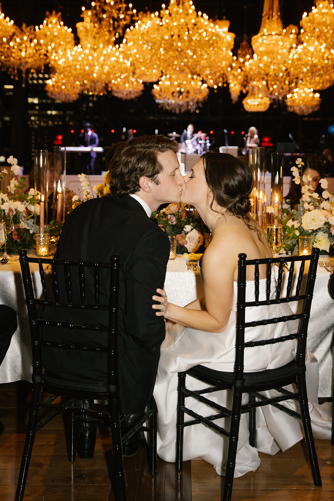 bride and groom kissing at wedding reception head table