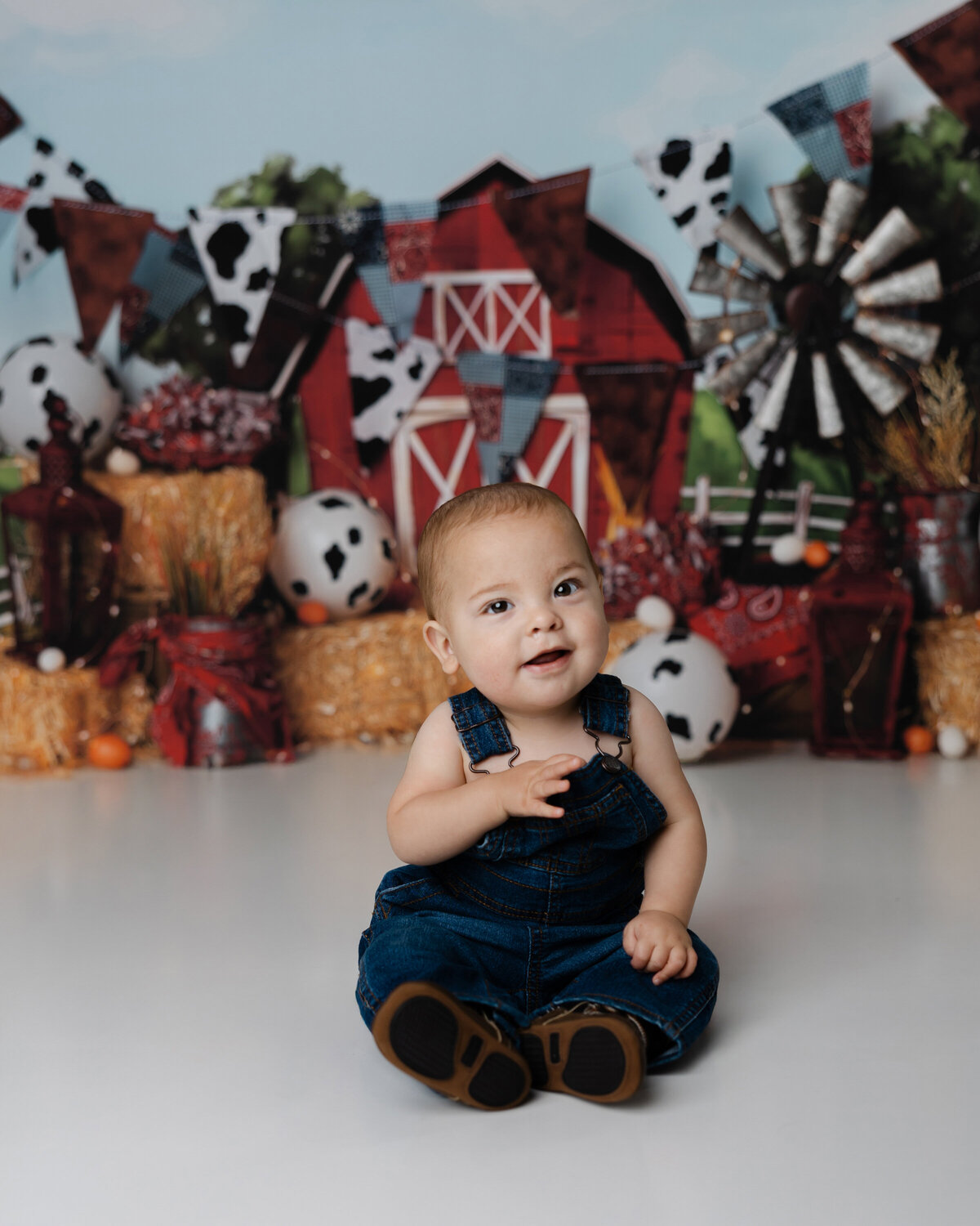 Adorable little one enjoying their cake smash in a farm-themed setting, giggling with joy. Captured by Yucaipa cake smash photographer Kaitlyn Dawn Photography.