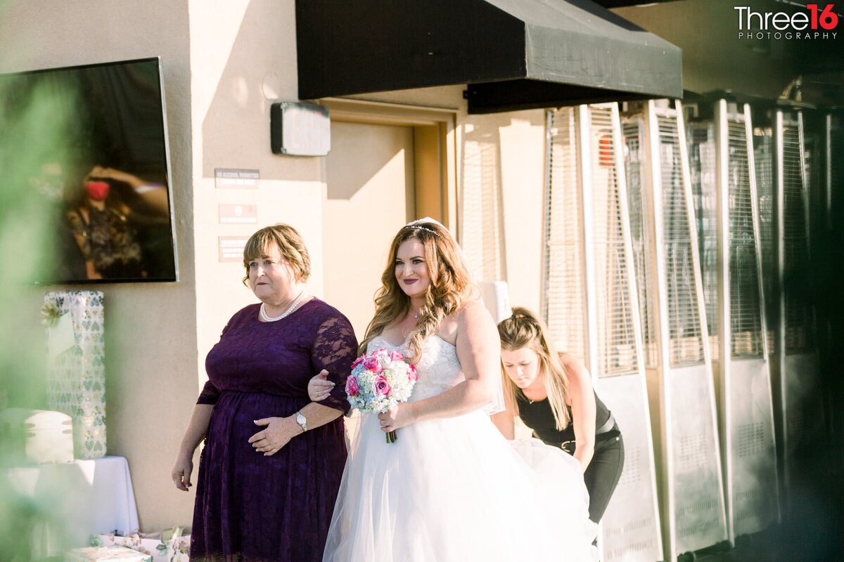 Bride is being escorted to the aisle by her mother