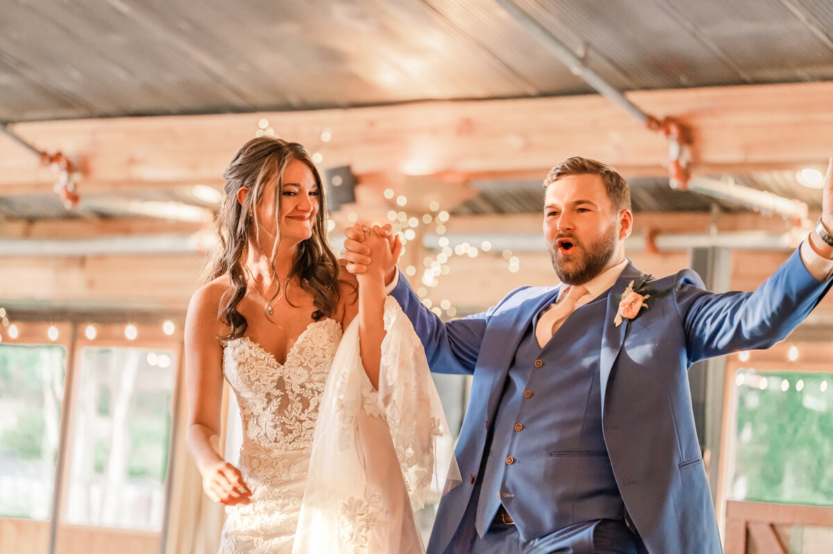 A bride and groom entering their wedding reception elated with joy from their North Carolina wedding photography wedding day