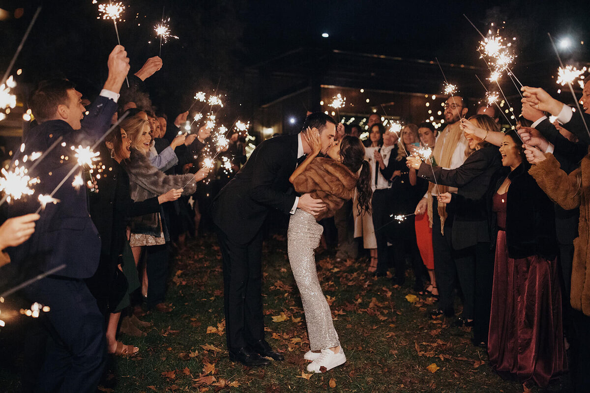 Bride and groom wedding exit with sparklers and fur coat