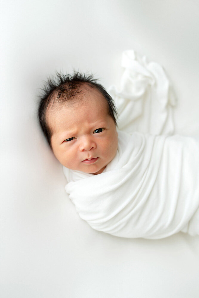 Newborn session of baby boy swaddled