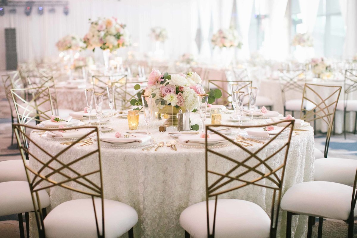 Ballroom wedding reception with gold and blush flowers