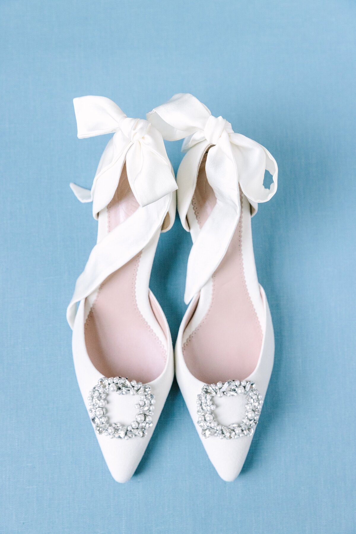 detail photo of white wedding shoes with ribbon tie ankle straps