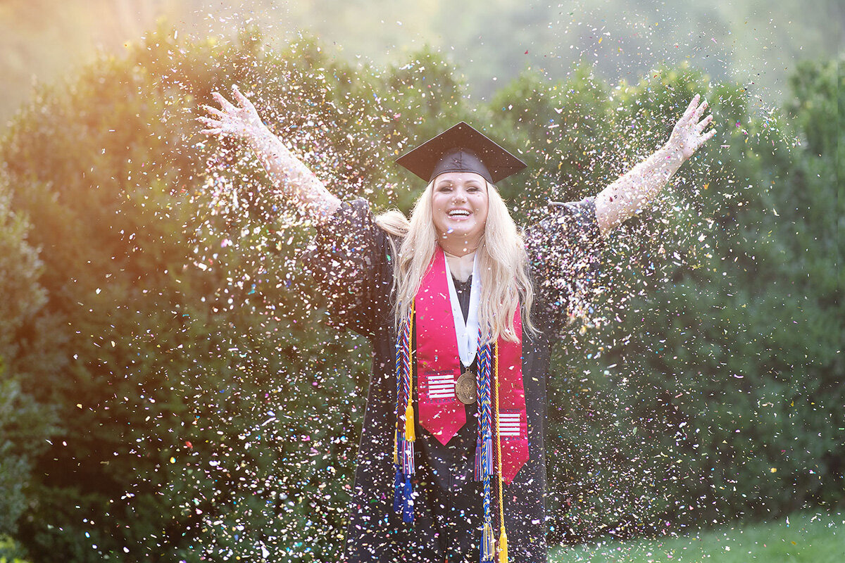 Senior session of young woman throwing confetti