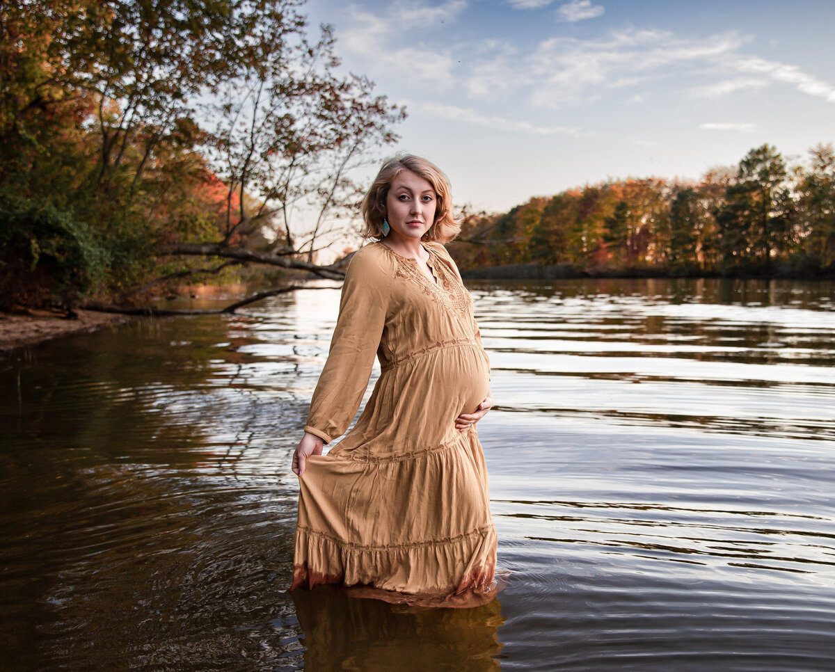 A pregnant woman poses for maternity pictures in a Maryland river.