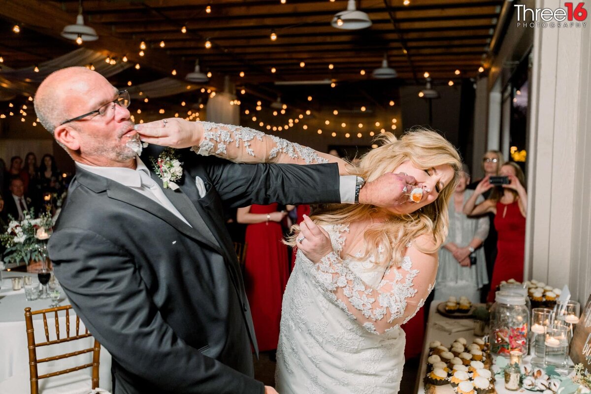 Bride and Groom smash wedding cake into each other's face