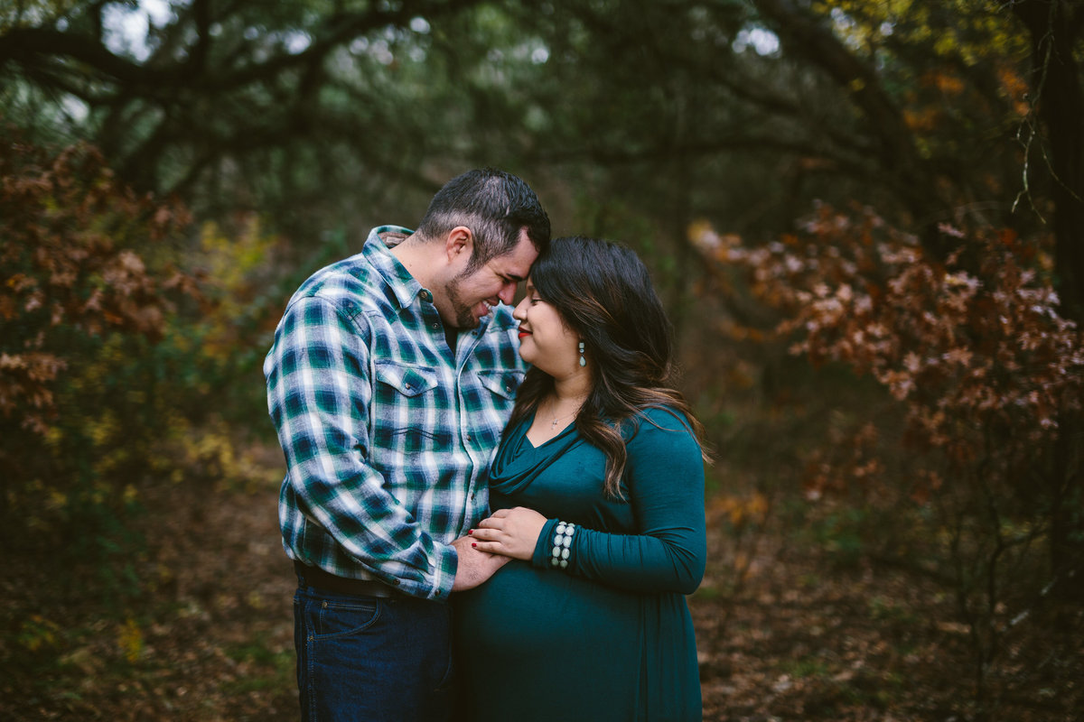 Pregnant couple holding each other for their maternity photography session in San Antonio.