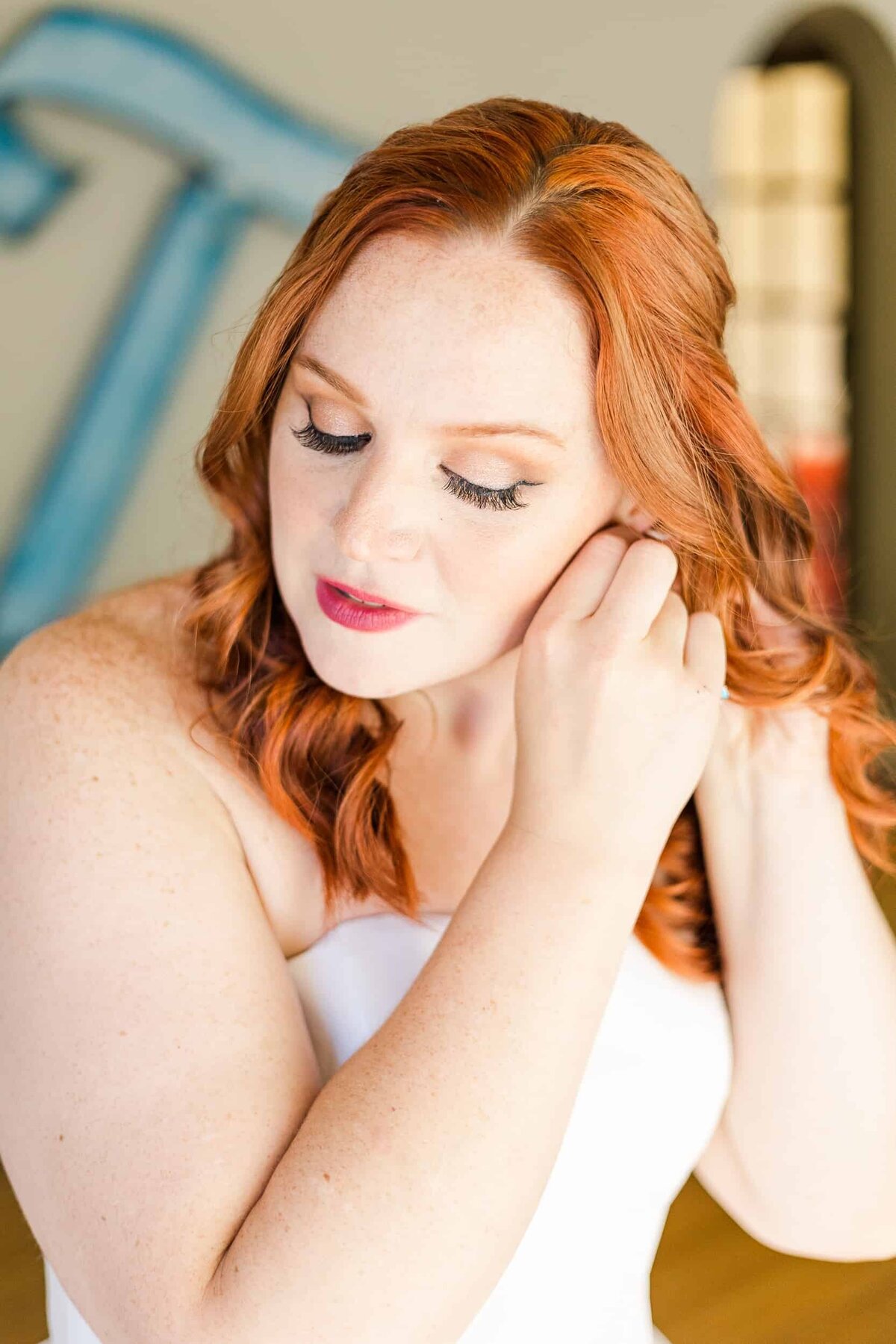 Red haired bride, putting on her earrings before the wedding at the museum of pop culture in Seattle
