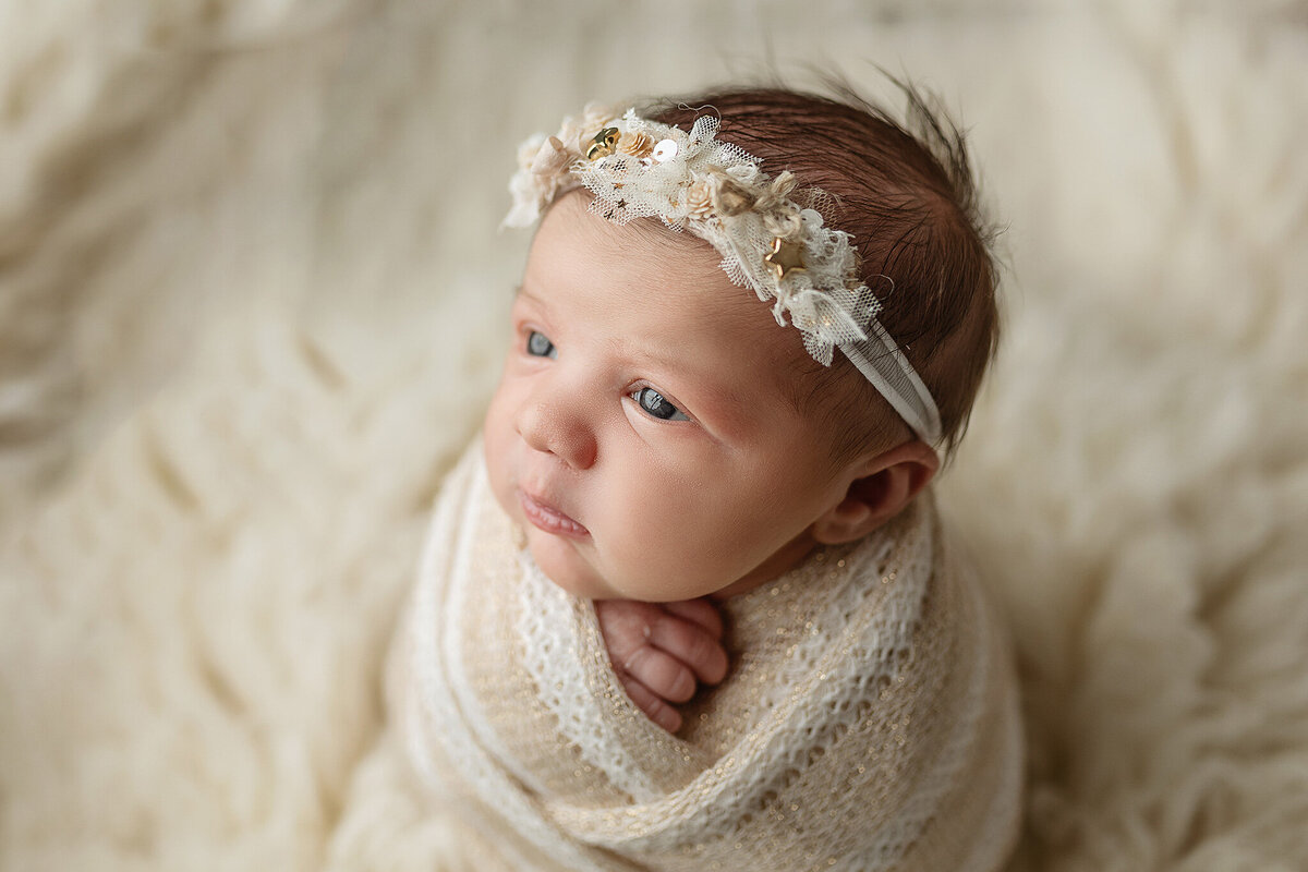 Sweet little girl wrapped up during her newborn session at Jennifer Brandes Photography studio.