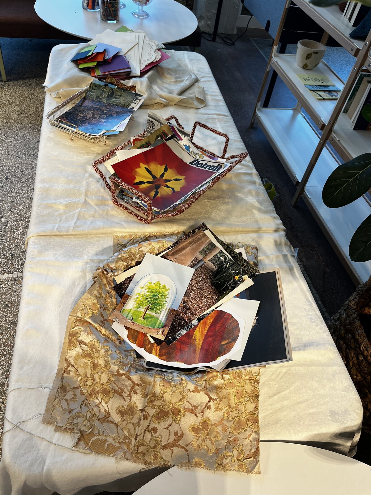 Table set up with different collage materials for participants during a collage workshop