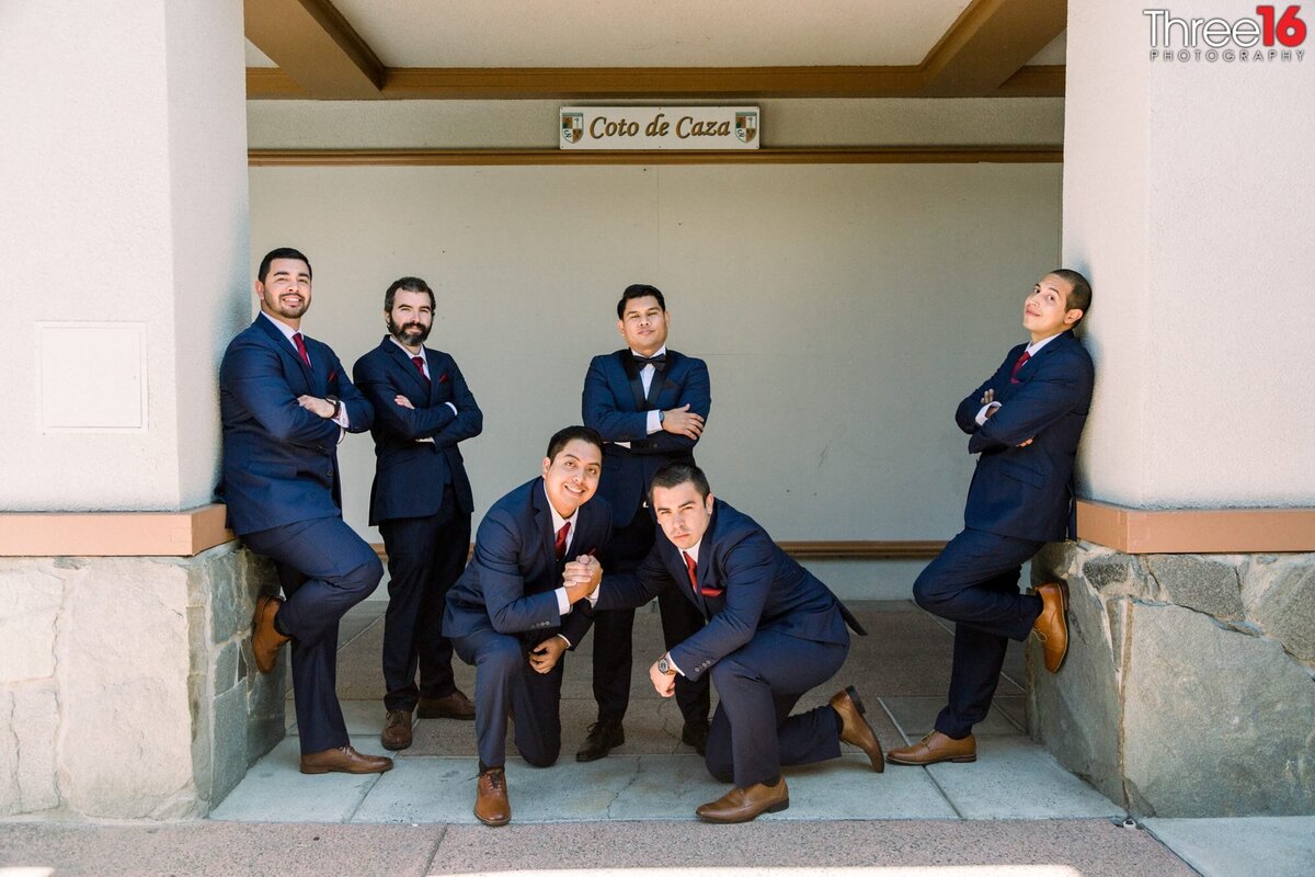 Groom and Groomsmen pose together acting as tough guys