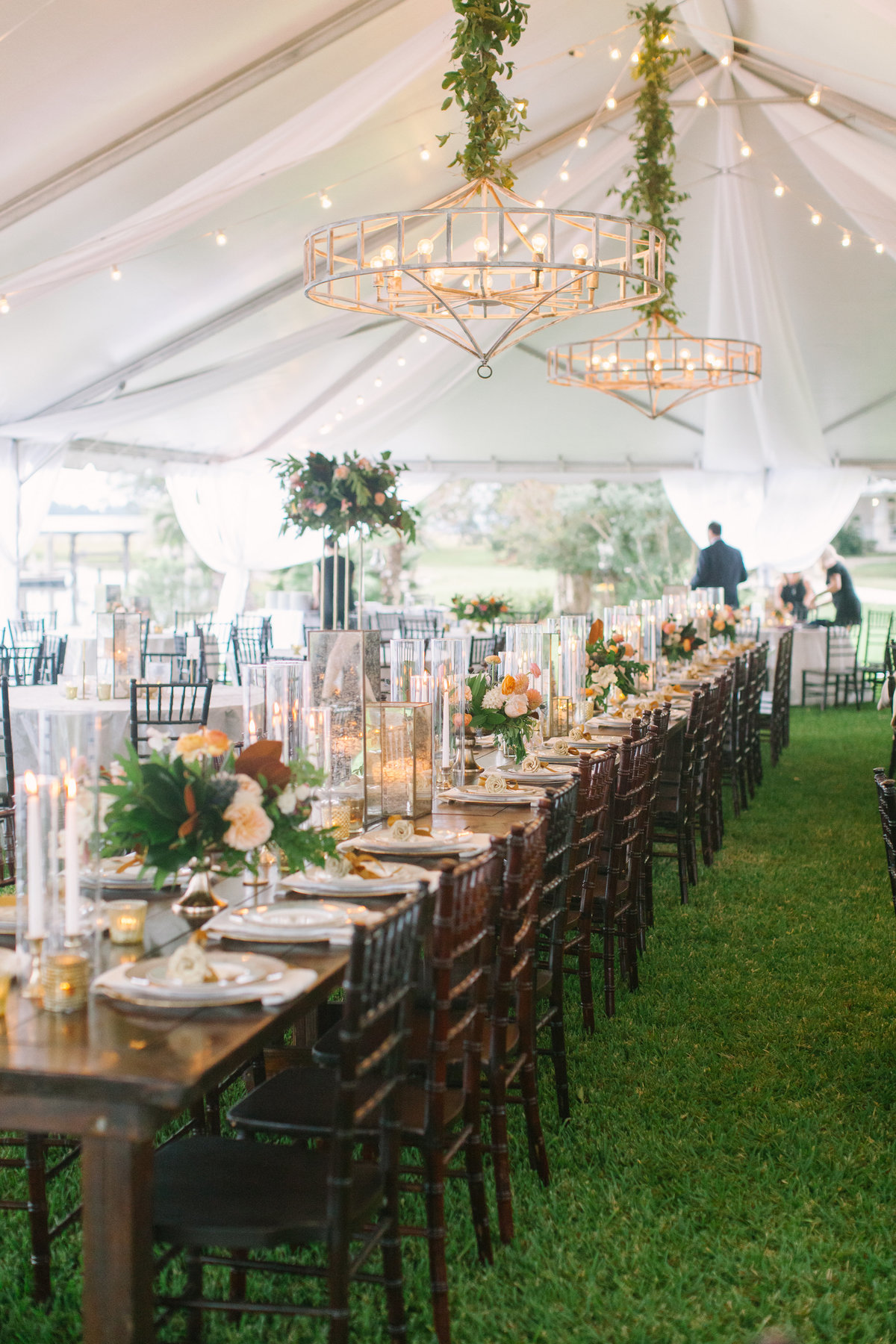 Southern Wedding Tent with Farm Tables Mahogany Chivari Chairs White Wash Chandelier Cafe Lighting Draping Candle Light