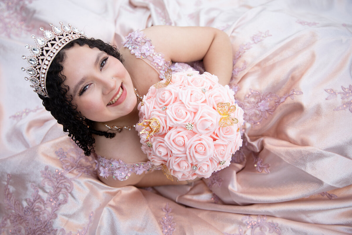 young Mexican-American teenage girl in crown with bouquet poses on her ballgown Saint Peter's Church Haverstraw quinceanera photographer Rockland County Milestone Images