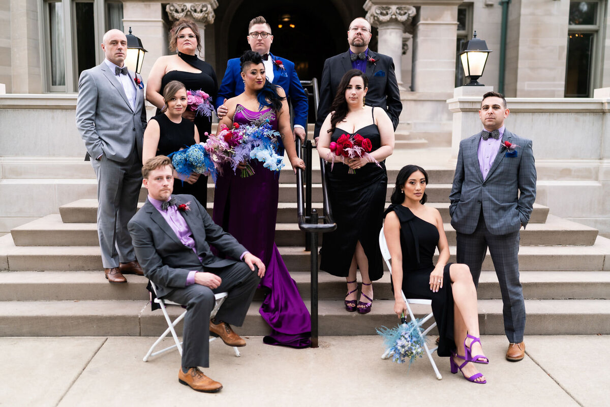 Wedding party poses with stoic faces in front of the American Swedish Institute in Minneapolis, Minnesota.