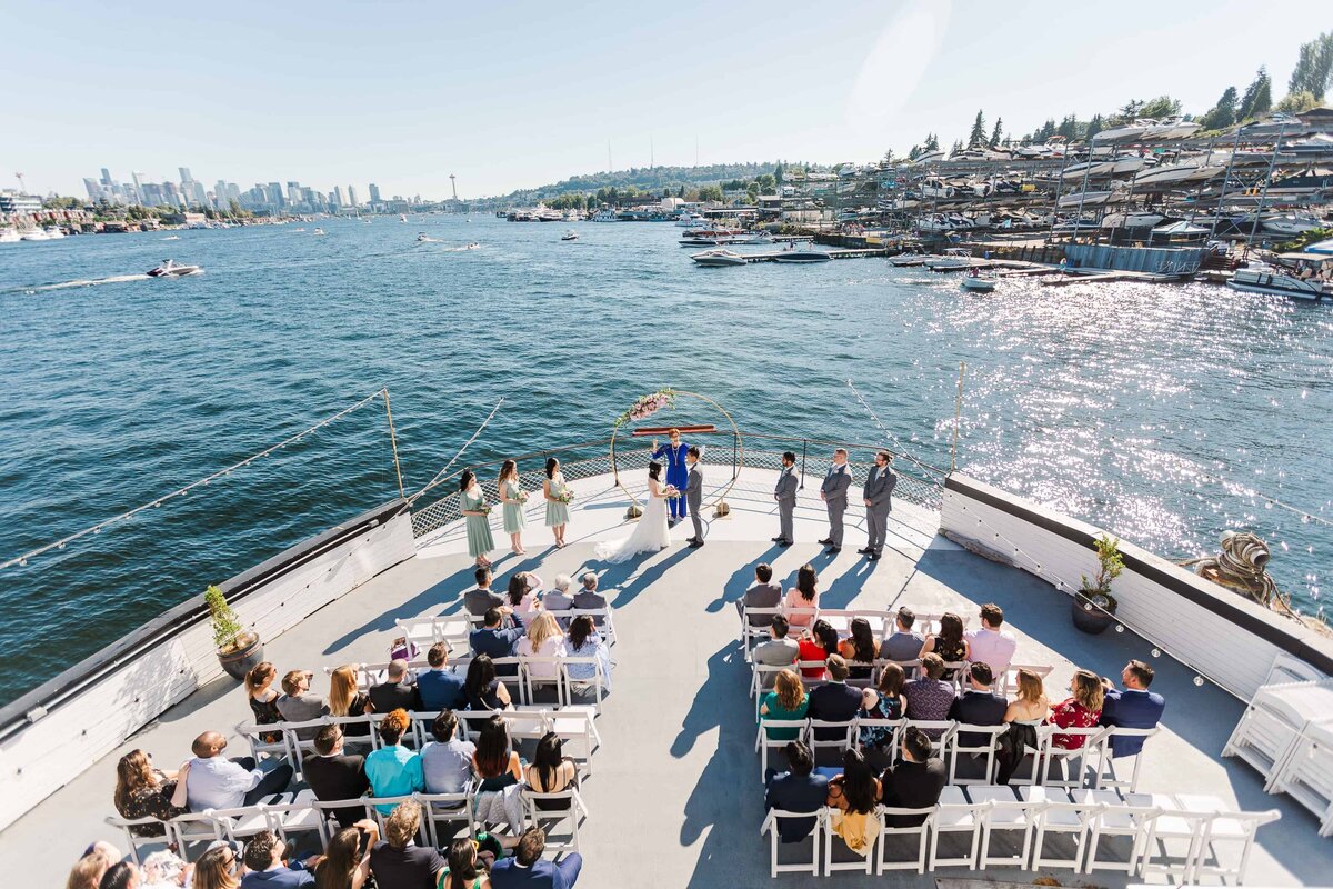 Wedding ceremony on the MV Skansonia boat, near sunset, overlooking the skyline of Seattle from Lake Union