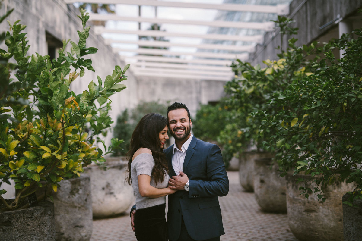 Engaged man and woman standing among citrus trees at the San Antonio Botanical Garden.