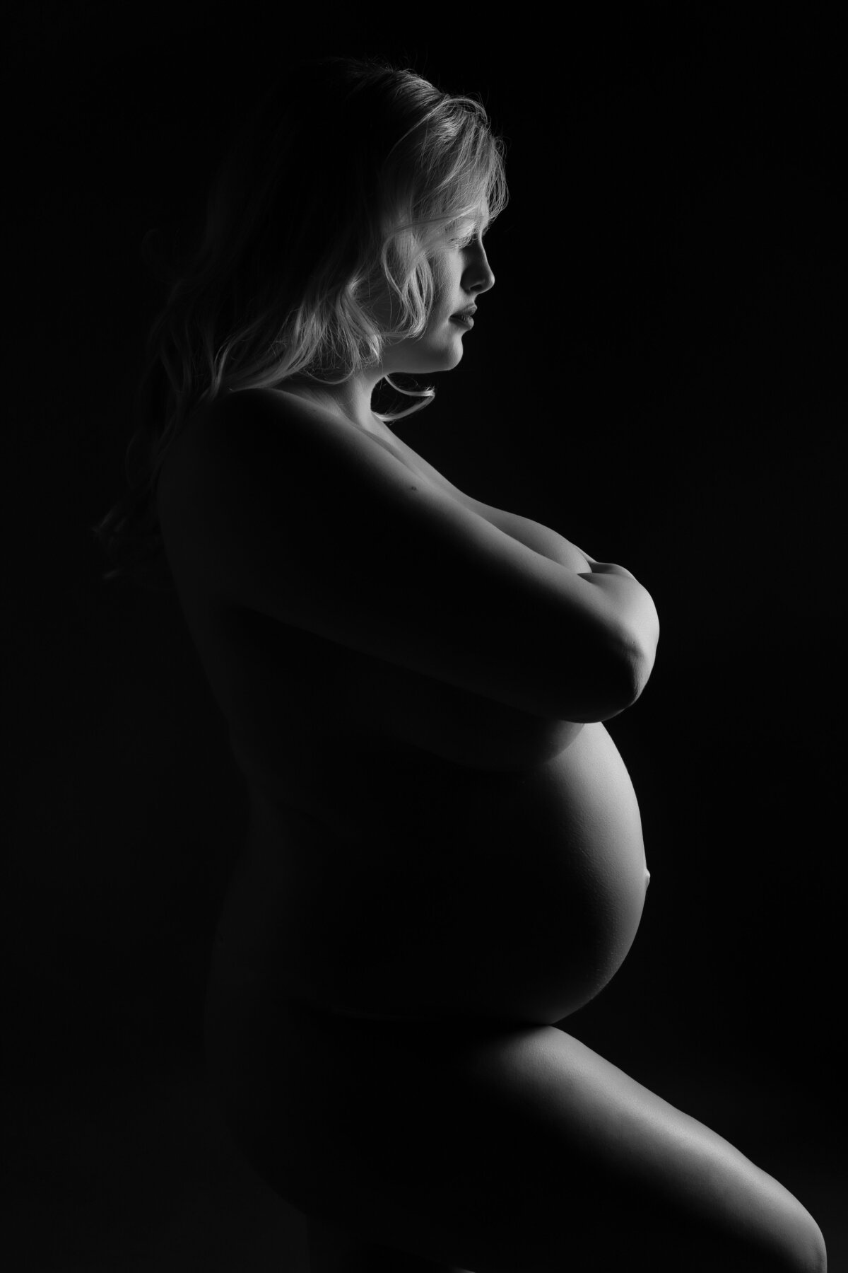 low key maternity lighting showing silhouette of a pregnant womans shape