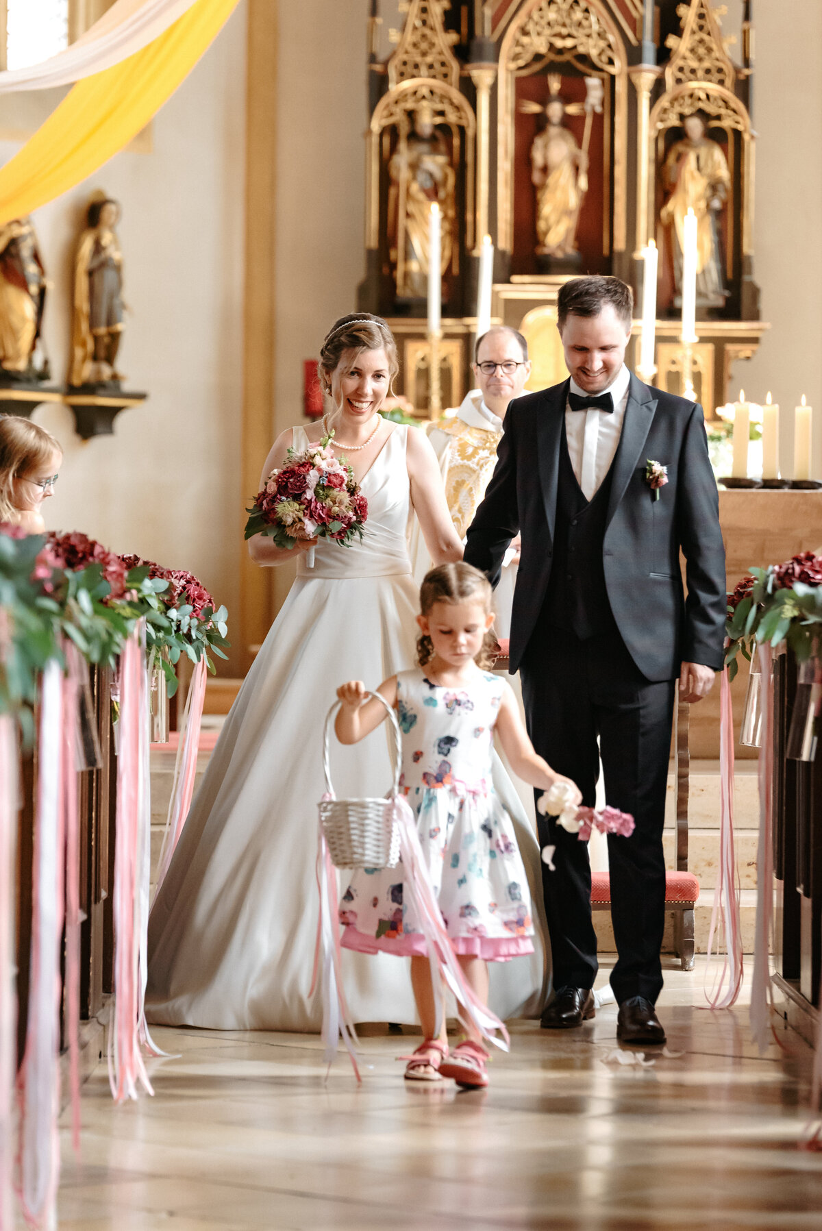 Brautpaar verlässt die Kirche mit Blumenmädchen Hochzeitsfotograf Starnberg