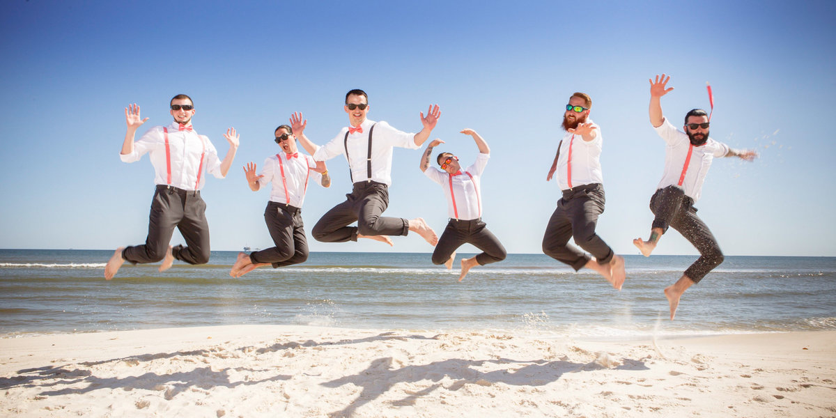 Groom & groomsmen jump in the air at Orange Beach, Alabama.