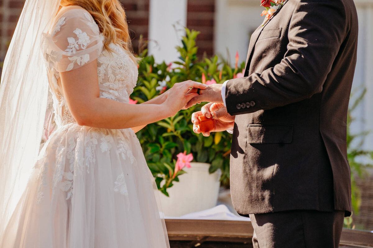 photo of a bride putting a ring on the groom's finger