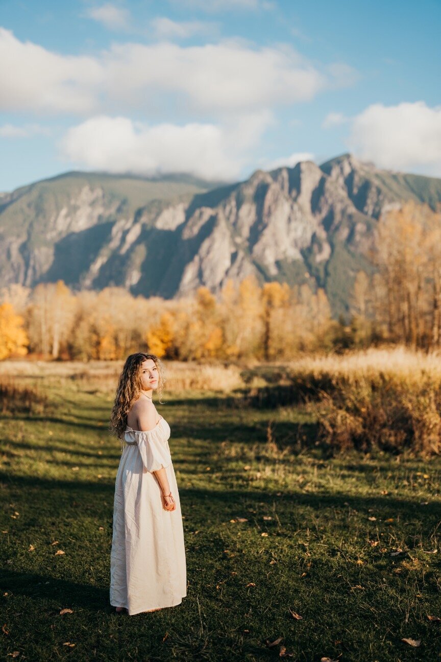 high-school-senior-girl-in-front-of-mountain-wearing-a-white-dress