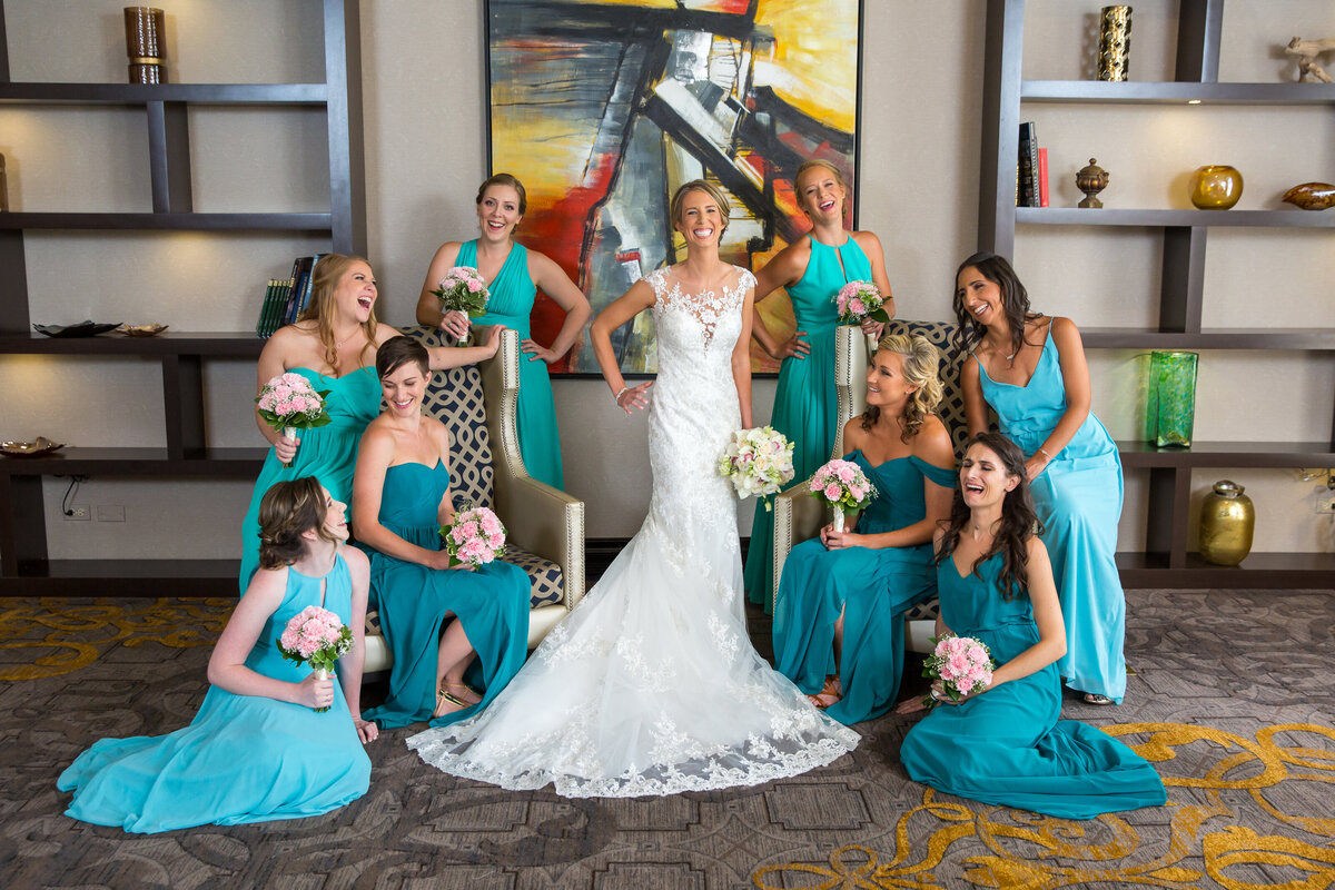 Bridesmaids wearing tiffany blue dresses for portrait are smiling at each other.