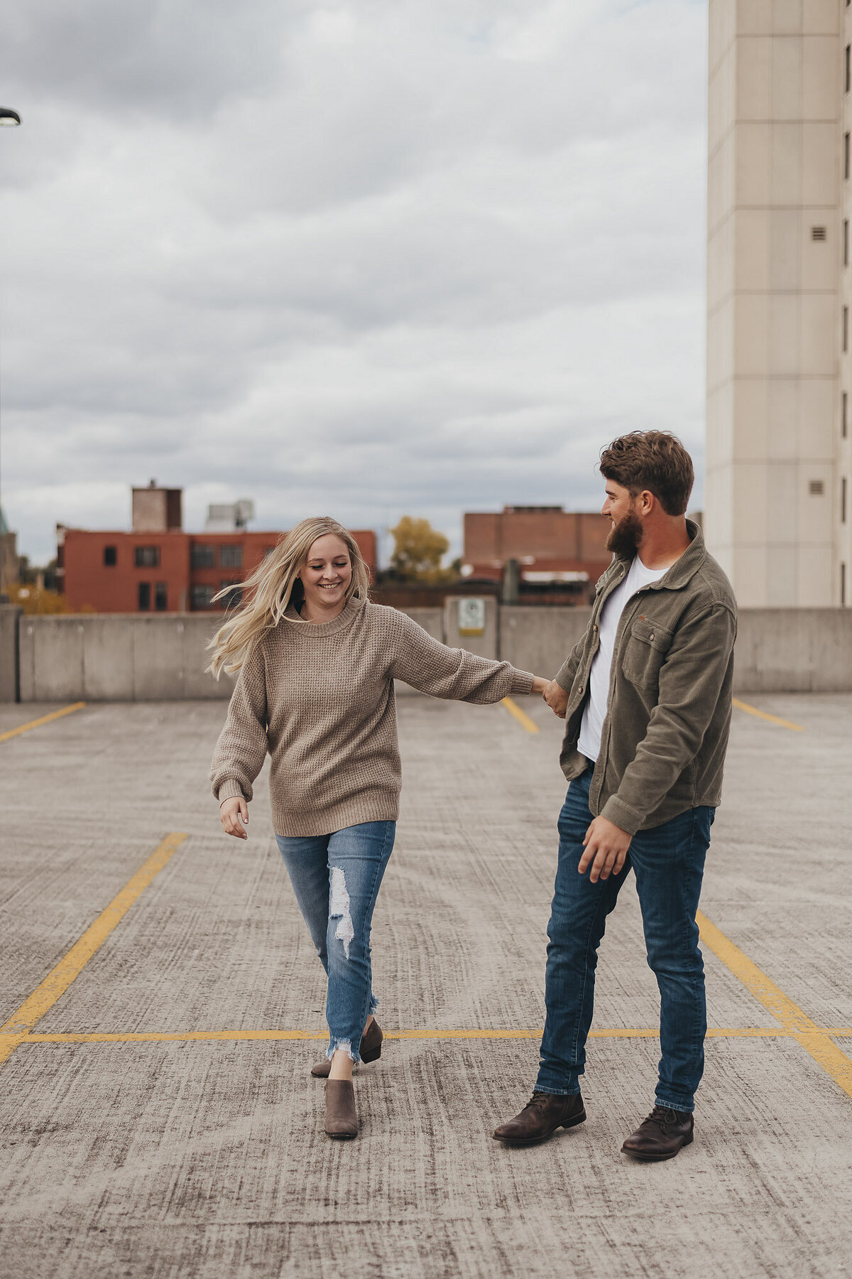 couple standing on a parking garage and smiling