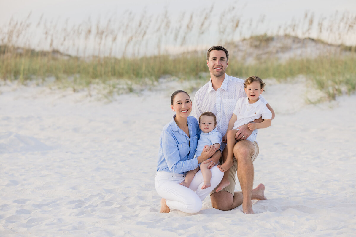 Parents crouched down holding two kids