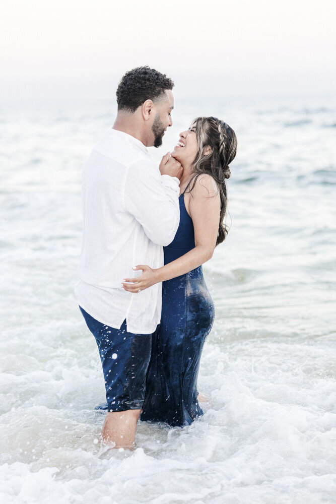 man and woman flirting playfully in ocean waves