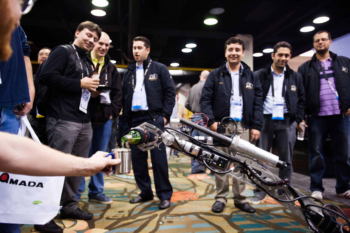 A robot arm pours a beer as part of a unique and intereactive demonstration at sales expo