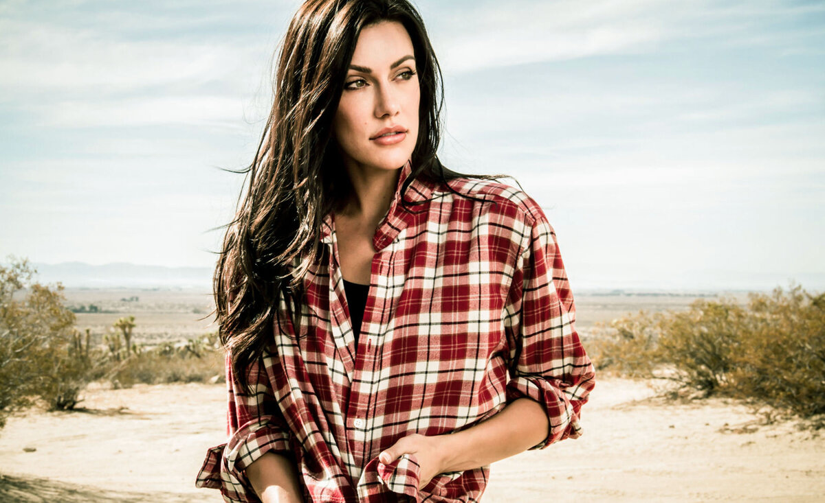 Country music photo Celeste Ziegler wearing plaid shirt looking right desert backdrop