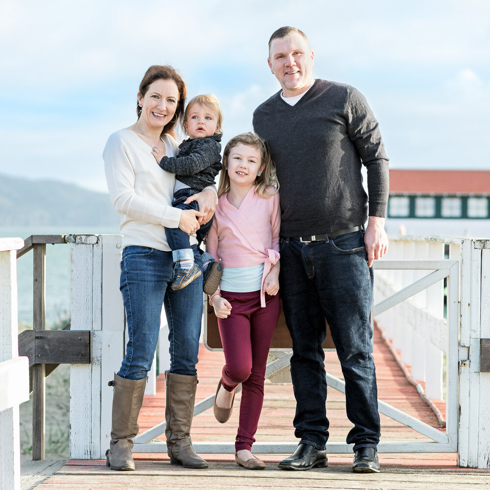 family smiling on pier